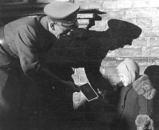 Немецкий офицер дарит девочке портрет Гитлера. Киев, осень 1941 года